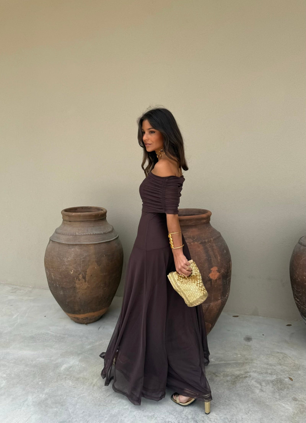 Woman in a dark brown off-the-shoulder maxi dress